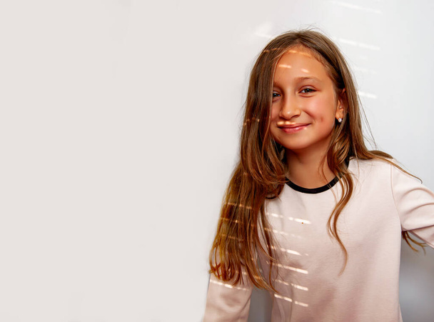 Πορτρέτο του χαριτωμένο ξανθό κοριτσάκι με φώτα ήλιο σε λευκό φόντο. - Φωτογραφία, εικόνα