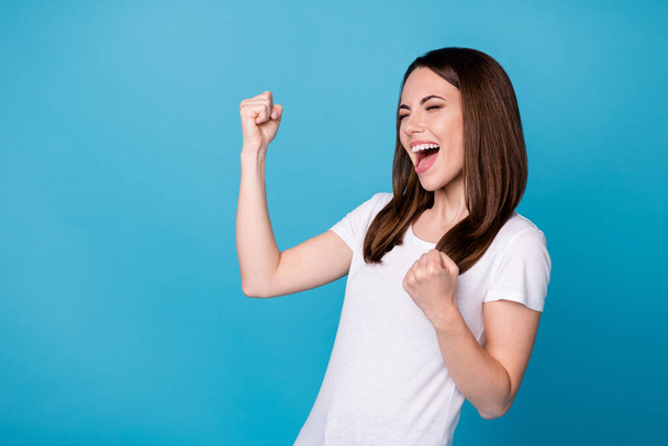 Photo of attractive pretty funny lady good mood raise fists screaming rejoicing overjoyed football sports fan supporter wear casual white t-shirt isolated blue color background - Foto, Imagen