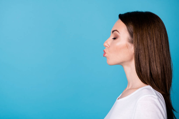 Closeup profile photo of attractive charming cute lady eyes closed sending air kisses side empty space boyfriend blind first date wear casual white t-shirt isolated blue color background - Φωτογραφία, εικόνα