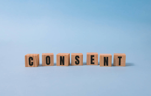Consent - word from wooden blocks with letters, consent concept, top view on blue background. - Фото, зображення