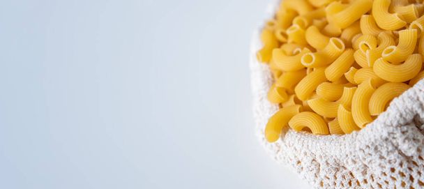 Raw dry uncooked Elbow Macaroni pasta spaghetti on white background. Good for basil tomato pesto sauce Homemade fresh Italian food organic whole wheat vegan spaghetti noodle for a healthy meal - Photo, Image