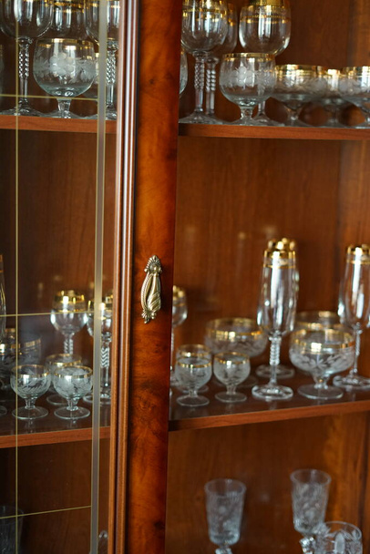Glass holiday tableware in a mahogany Cabinet. - Zdjęcie, obraz