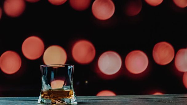 Whiskey in a glass on a bokeh background, a glass of whiskey close-up - Фото, зображення