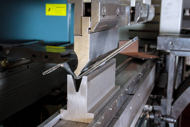 The process of bending sheet metal on a hydraulic bending machine. Metalworking plant. - Photo, Image