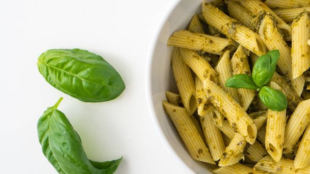 Pâtes italiennes maison penne nouilles cuisiner des aliments avec du basilic frais vert biologique feuille de fromage sauce pesto noix repas sain pour végétarien végétalien - Photo, image