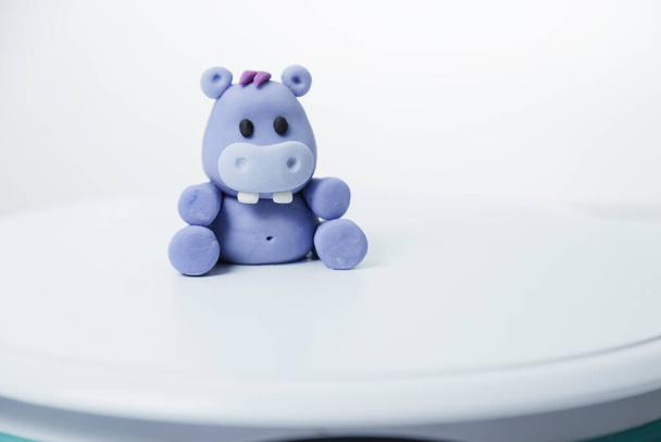 Bembeyaz arka planda elle boyanmış kilden yapılmış küçük bir oyuncak bebek. - Fotoğraf, Görsel