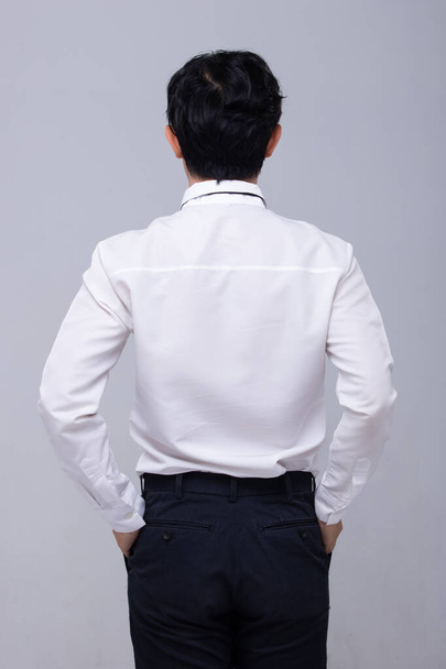 Office Man fehér ing fordítsa vissza a visszapillantó és kifejezni érzés keresztül a fejét és a kezét a nagy üres másolási hely szürke háttér elszigetelt - Fotó, kép