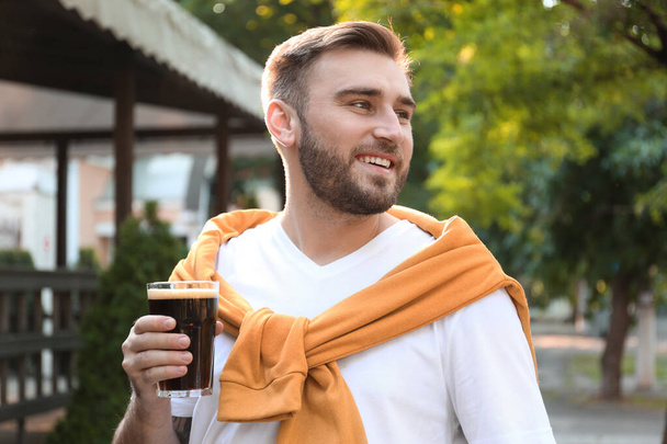 Handsome man with cold kvass outdoors. Traditional Russian summer drink - Foto, immagini