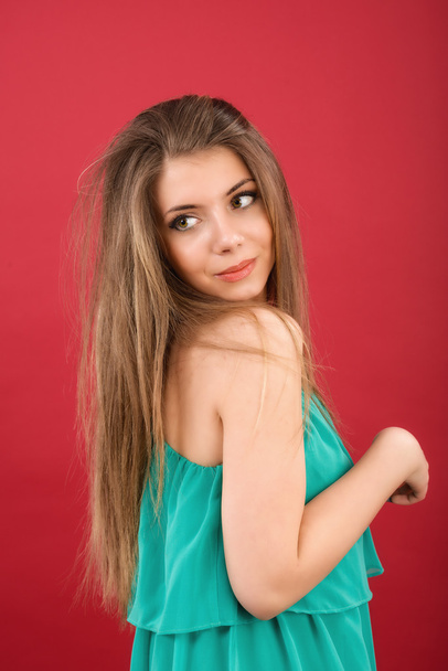 Portrait of beautiful woman on red background - Fotografie, Obrázek