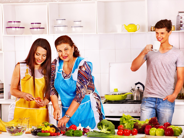 Mature woman with family preparing at kitchen. - Photo, Image