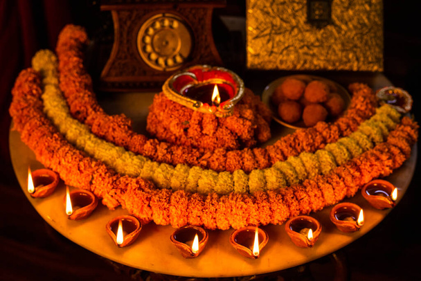 Diwali brillante Diya, flores, dulces y regalos dispuestos en forma circular formando un diseño con espacio de copia, enfoque selectivo, festival indio - Foto, Imagen