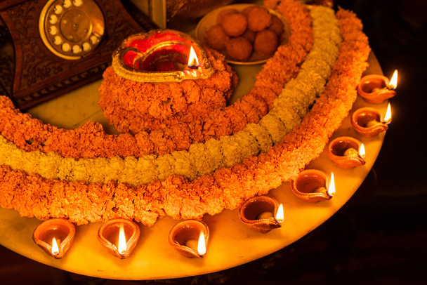 Diwali brillante Diya y flores dispuestas en forma circular formando un diseño con espacio de copia, enfoque selectivo - Foto, Imagen