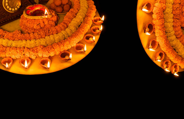 Diwali brillante Diya y flores dispuestas en forma circular formando un diseño con espacio de copia, enfoque selectivo - Foto, imagen