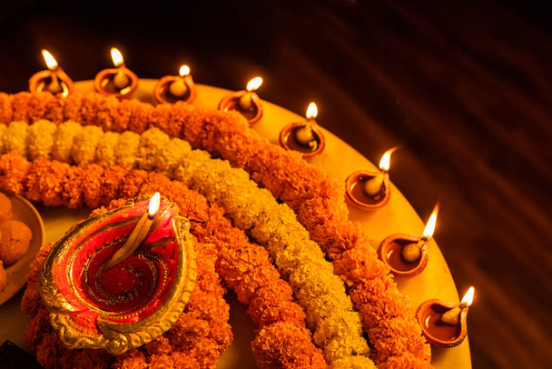 Happy Diwali - Clay Diya lámparas encendidas durante Dipavali, festival hindú de la celebración de las luces. Colorida lámpara de aceite tradicional diya y dulces sobre fondo de mármol - Foto, imagen