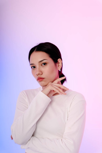Portré fiatal ázsiai nő fehér hosszú ujjú pasztell háttér. Divatkoncepció. - Fotó, kép