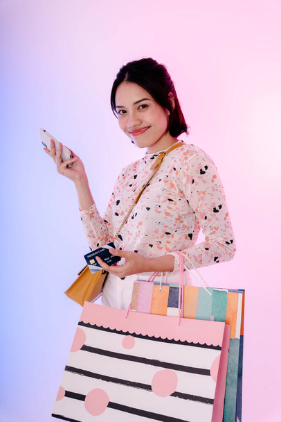 Retrato de una joven asiática bien vestida sosteniendo bolsas de papel de compras. Simular el diseño. - Foto, Imagen