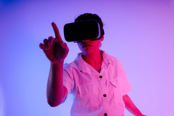 Portrait of young asian woman using VR headset goggles to play game and video. - Photo, Image
