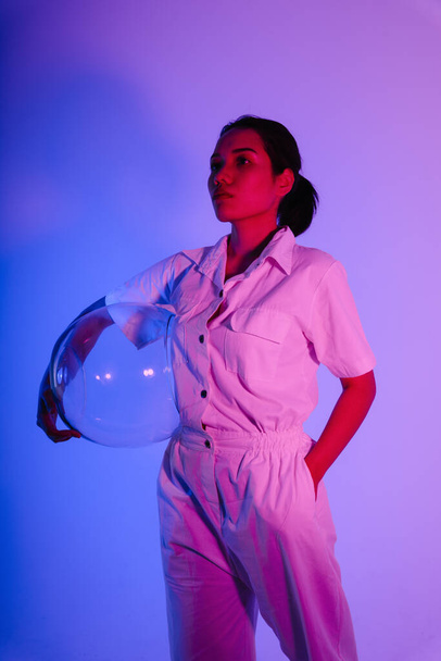 Portrait de femme astronaute asiatique avec casque spatial au néon. - Photo, image