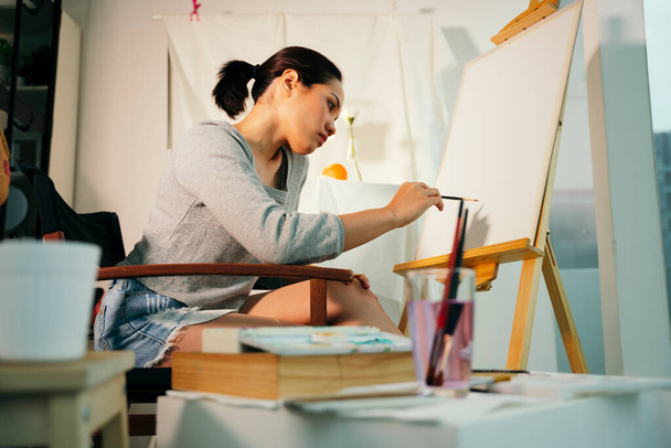 Female professional artist painting colour on canvas in studio. - Valokuva, kuva