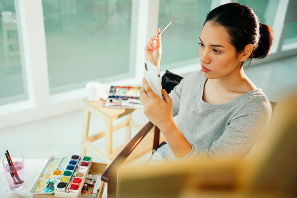Retrato de joven artista asiática mujer pintura sobre lienzo en estudio. - Foto, Imagen