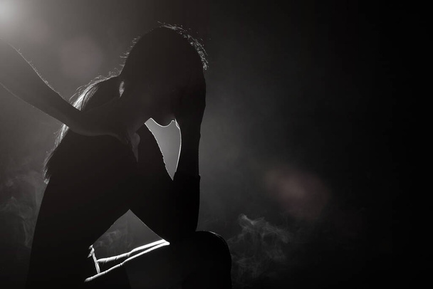 Silhouette αφηρημένη του υποστηριζόμενου αδελφού χέρι για να βοηθήσει αδελφή γυναίκα εκφράζει λύπη, κλάμα και μοναξιά από ραγισμένη καρδιά και το πρόβλημα. Φωτιζόμενος καπνός χαμηλή έκθεση σκοτεινό φόντο αντίγραφο χώρου - Φωτογραφία, εικόνα