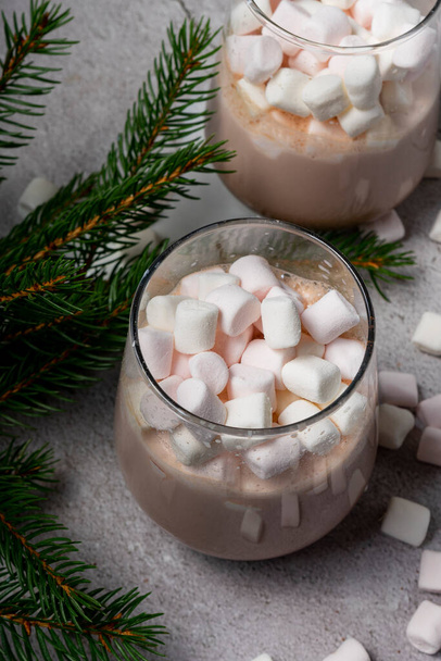 foco seletivo. Bebida de Natal. cacau de chocolate com pequenos marshmallows brancos. com galhos de árvore - Foto, Imagem