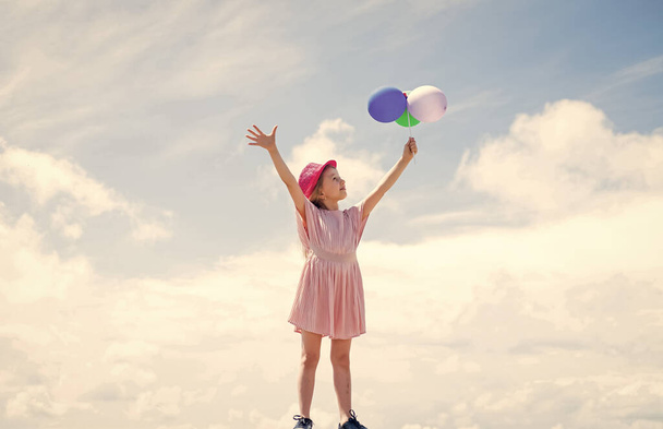 international childrens day. happy childhood. little child with balloons. Entertainment birthday concept. freedom. child having party and dancing with balloons in hands. kid having fun - Photo, Image
