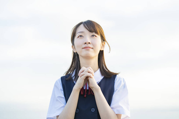 Азійка - старшокласниця в молитві. - Фото, зображення