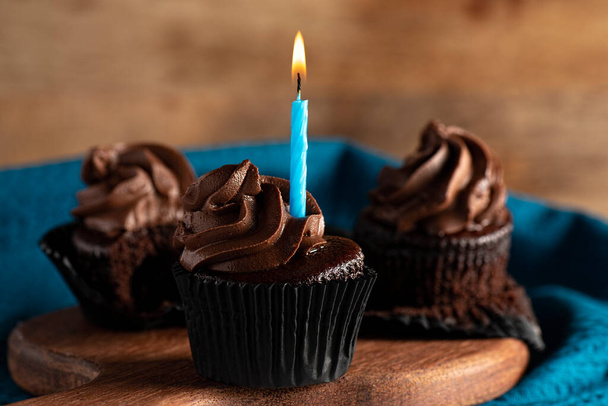 Chocolate icing cupcakes, food background. - 写真・画像