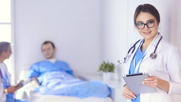 Doctor checking heart beat of patient in bed with stethoscope - Fotó, kép