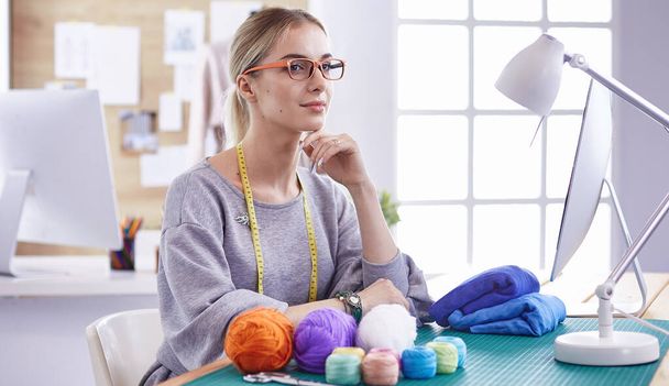 красива молода дівчина на фабриці зі швейною машинкою за столом
 - Фото, зображення