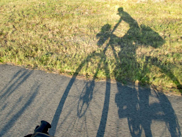 ombre d'un motard avec vélo sur la route - Photo, image
