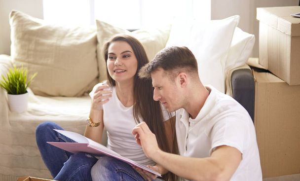 Young Hispanic couple looking at blueprints of new home, high angle view - Photo, Image