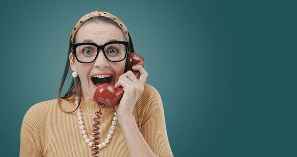 Woman receiving great news on the phone, she is cheerful and surprised - 写真・画像