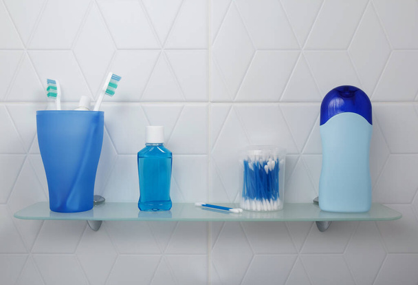 Estante en un baño luminoso con productos de cuidado oral y gel de ducha - Foto, imagen