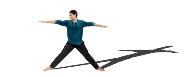 Shot of a teenage boy doing stretching exercises isolated on a white background along with his shadow. - Foto, Bild