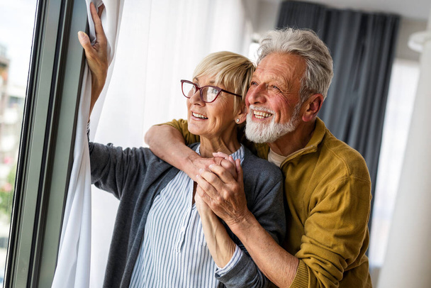 Happy senior couple in love hugging and bonding with true emotions at home - Foto, imagen