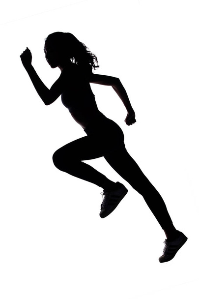 Silhouet slanke body van Young Fitness Woman beginnen vooruit te lopen in volledige lichaamslengte. Hoge contrast witte achtergrond kopiëren ruimte - Foto, afbeelding