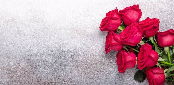 Horizontal banner with bouquet of red roses on stone background. Valentines day greeting card - Image - Fotoğraf, Görsel