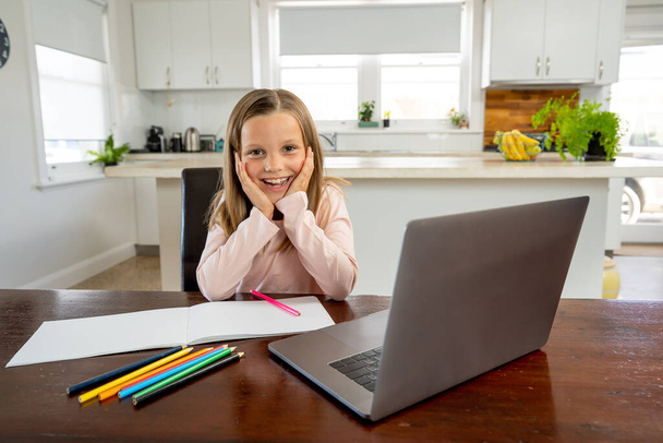 Happy Schoolgirl on laptop watching online lesson learning remotely at home in self-isolation. Education, Quarantines and Schools reopening or shutting down in-person learning due to COVID-19. - Foto, Imagem
