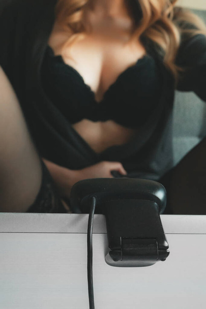 Verleidelijke vrouw die werkt als webcam model. Toont haar borsten. - Foto, afbeelding