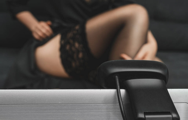 Seductive woman working as webcam model. Removing stockings. - Фото, изображение