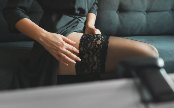 Seductive woman working as webcam model. Removing stockings. - Фото, зображення