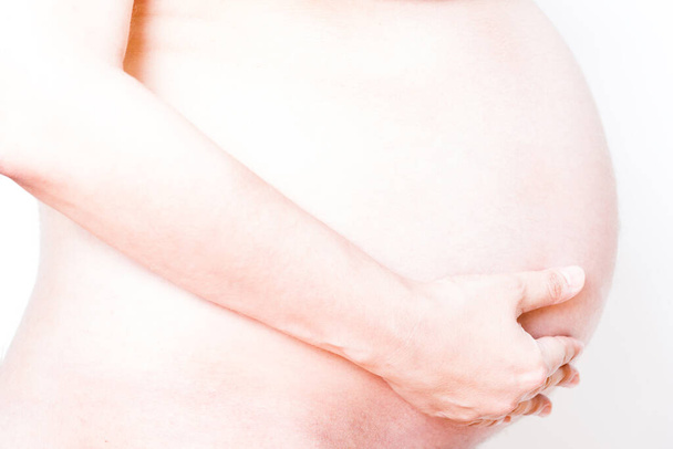крупным планом к животу беременной женщины на 40 неделе. - Фото, изображение