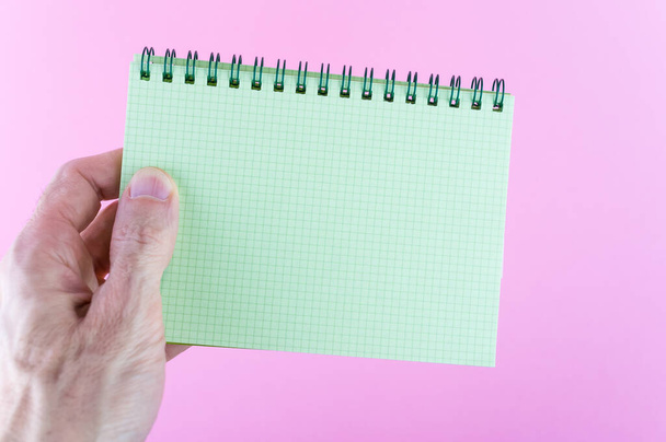 A closeup shot of a blank notebook on a pink surface - Фото, зображення