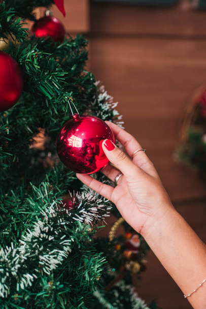 A vertical closeup shot of decorating a Christmas tree - Photo, Image