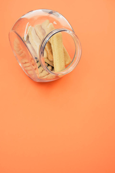A vertical shot of a bowl of cookies on an orange surface - Foto, immagini