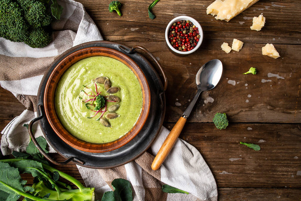 Spring detox broccoli green cream soup with microgreen, pumpkin seeds on rustic background, banner, catering menu recipe place for text, top view. - Photo, Image