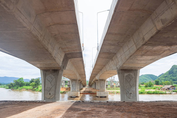 Yeni köprünün altından perspektif inşaatı. Chiang Rai, Tayland 'daki Maekok nehri üzerindeki köprü. - Fotoğraf, Görsel