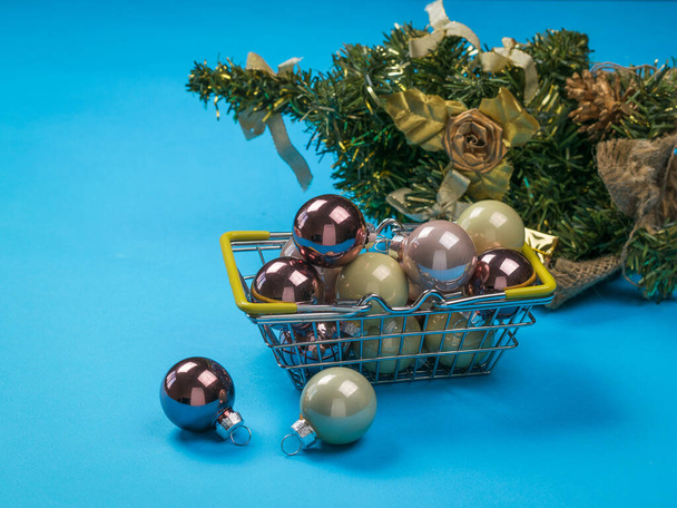 Metal basket with glass balls on the background of a Christmas tree. - Photo, Image